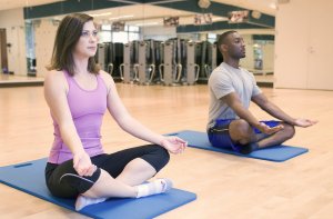 15407-a-man-and-woman-practicing-yoga-in-a-fitness-center-pvyoga2